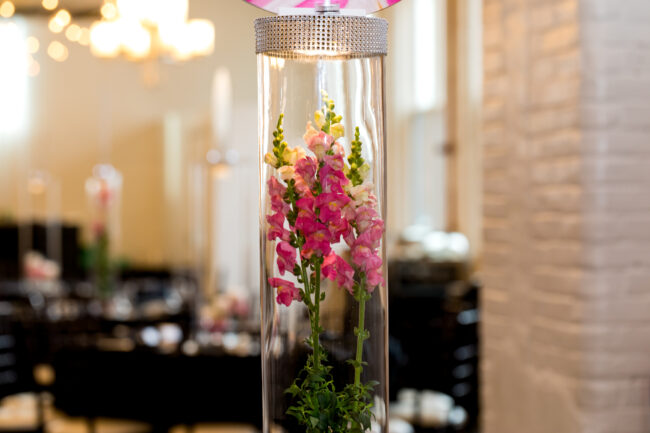 Giant vase centerpiece with florals and picture toppers.