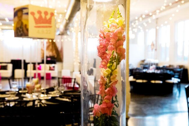 Giant vase centerpiece with florals and picture toppers.