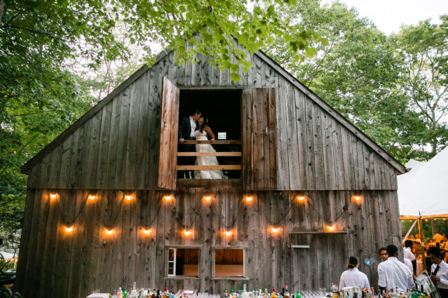 Bride and Groom looking out barn window