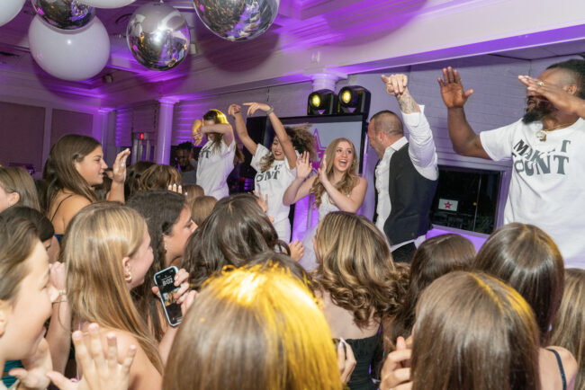 Mitzvah girl dancing with Emcee and dancers on stage