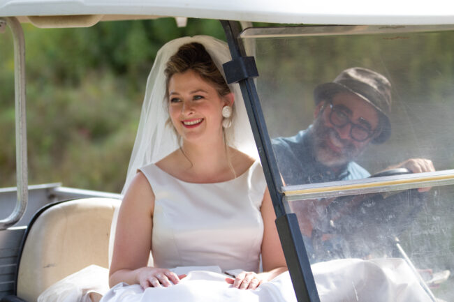Bride getting golf kart ride to first look