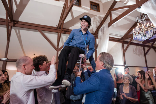 Mitzvah boy lifted in chair during hora