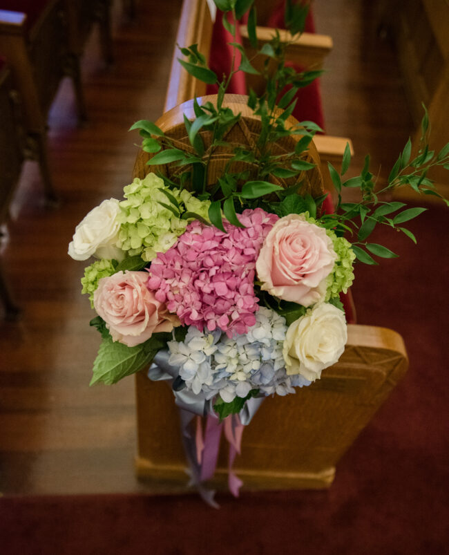Florals lining the pews in sanctuary