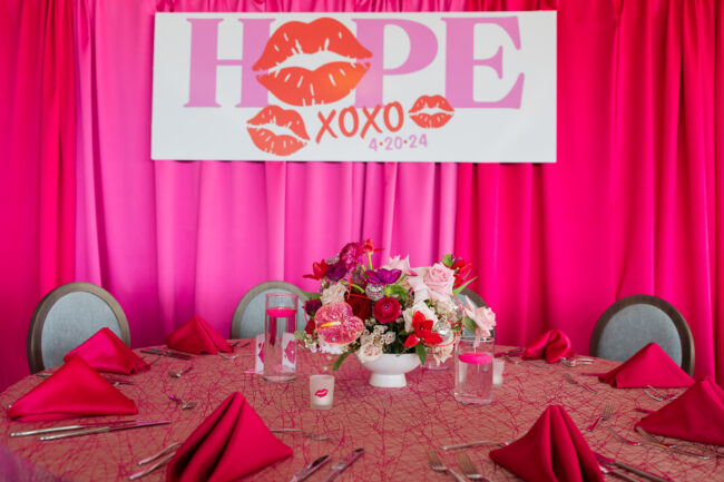 Pink pipe and drape with giant logo'd sign