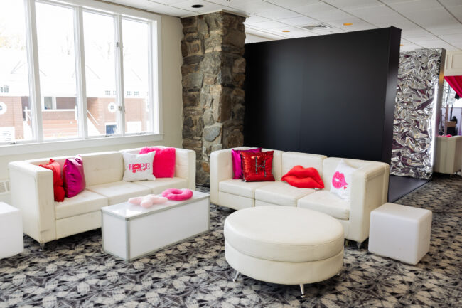 Kids lounge in chic white with colorful pink logo'd throw pillows.