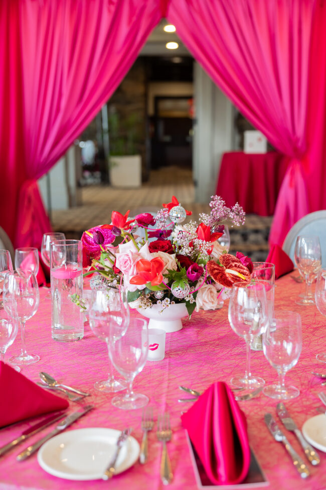 Table scape with pink florals, acrylic vases and logo'd votives