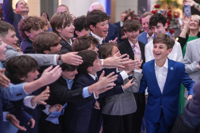 mitzvah boy high-fiving friends during introduction