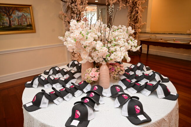 Logo'd trucker hat place cards with floral arrangement