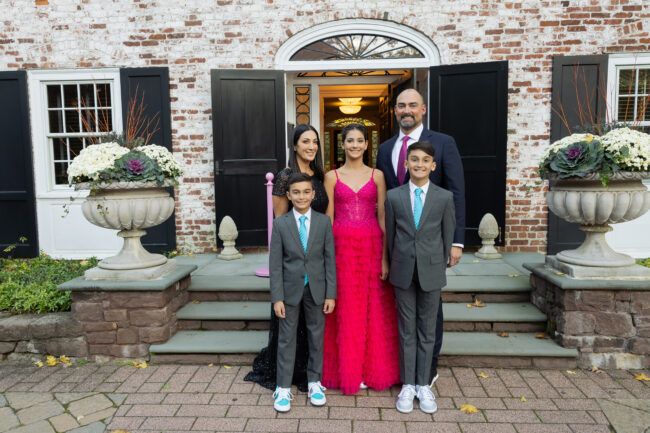 Mitzvah family posing for photos outside house