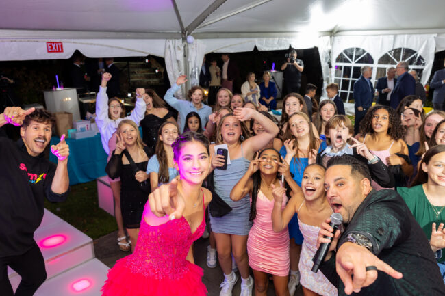 Mitzvah girl posing with MC and friends 