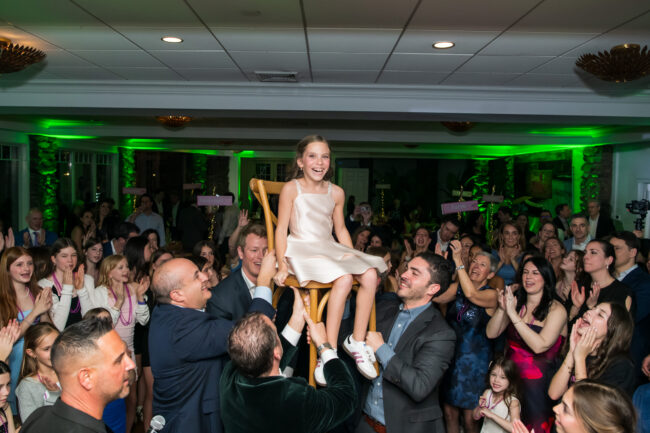 Mitzvah sister up in chair during Hora