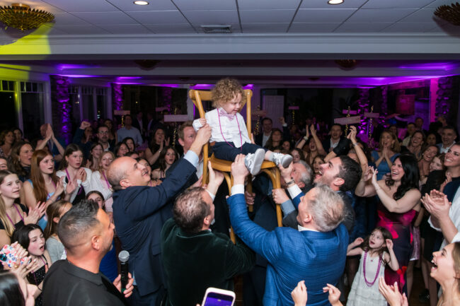 Mitzvah brother up in chair during Hora