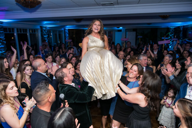 Mitzvah mom up in chair during Hora