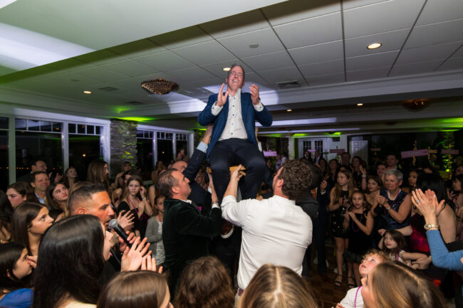 Mitzvah dad up in chair during Hora